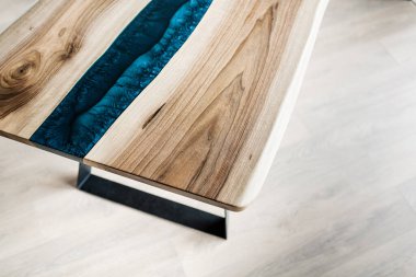 Doğal ahşaptan ve mavi epoksiden yapılmış bir masa.