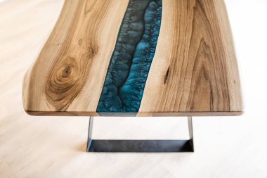 Doğal ahşaptan ve mavi epoksiden yapılmış bir masa.