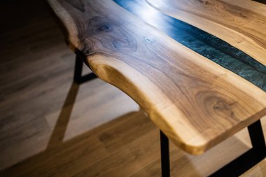 Doğal ahşaptan ve mavi epoksiden yapılmış bir masa.