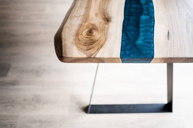 Doğal ahşaptan ve mavi epoksiden yapılmış bir masa.