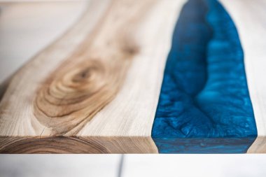 Doğal ahşaptan ve mavi epoksiden yapılmış bir masa.