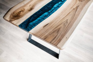 Doğal ahşaptan ve mavi epoksiden yapılmış bir masa.