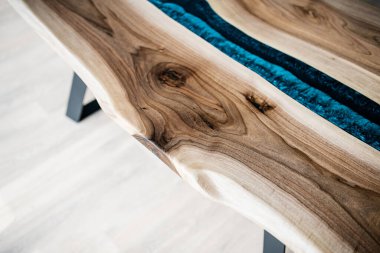 Doğal ahşaptan ve mavi epoksiden yapılmış bir masa.