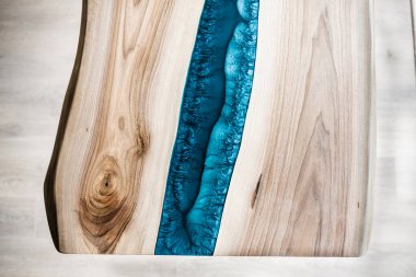 Doğal ahşaptan ve mavi epoksiden yapılmış bir masa.