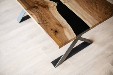 Doğal ahşaptan ve siyah epoksiden yapılmış bir masa.