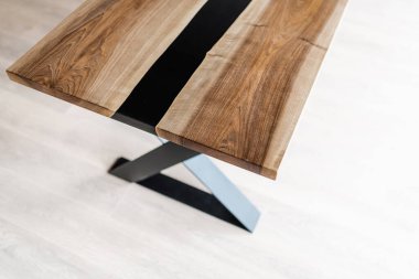 Doğal ahşaptan ve siyah epoksiden yapılmış bir masa.