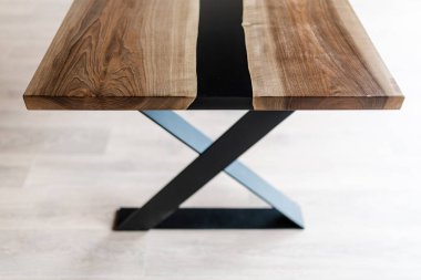 Doğal ahşaptan ve siyah epoksiden yapılmış bir masa.