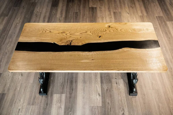 table made of wood and black epoxy resin on wrought metal legs