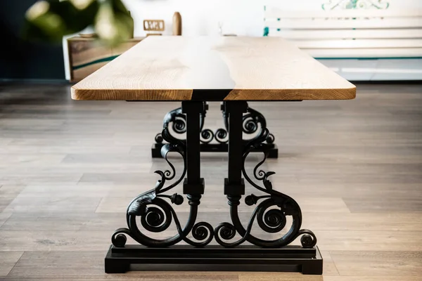 table made of wood and black epoxy resin on wrought metal legs