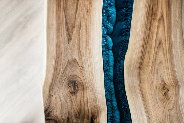 Doğal ahşaptan ve mavi epoksiden yapılmış bir masa.