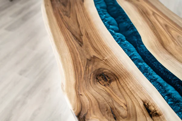 Doğal ahşaptan ve mavi epoksiden yapılmış bir masa.