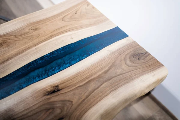 Doğal ahşaptan ve mavi epoksiden yapılmış bir masa.
