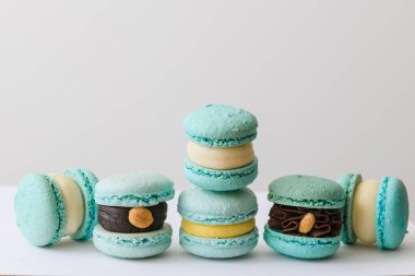 Beyaz arka planda farklı dolguları olan mavi, lezzetli kurabiyeler.