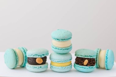 Beyaz arka planda farklı dolguları olan mavi, lezzetli kurabiyeler.