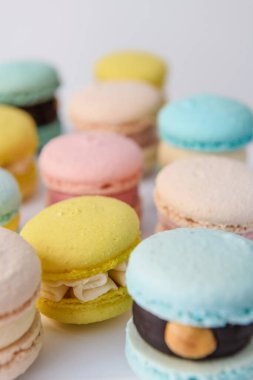 Beyaz arkaplanda düzenlenmiş bir sürü renkli badem kurabiyesi.