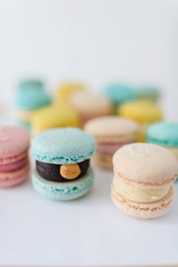 Beyaz arka planda bir sürü yeni pişmiş badem kurabiyesi.