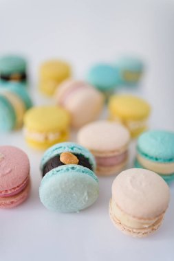 Beyaz arka planda bir sürü yeni pişmiş badem kurabiyesi.