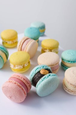 Beyaz arka planda bir sürü yeni pişmiş badem kurabiyesi.