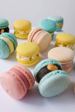 Beyaz arka planda bir sürü yeni pişmiş badem kurabiyesi.