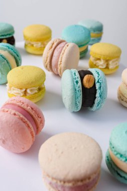 Beyaz arka planda bir sürü yeni pişmiş badem kurabiyesi.