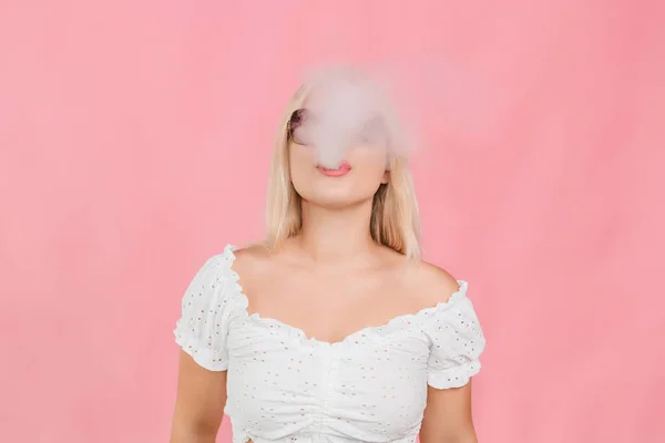 Genç Sarışın Gözlüklü Kız Pembe Arka Planda Sigara Içiyor — Stok fotoğraf