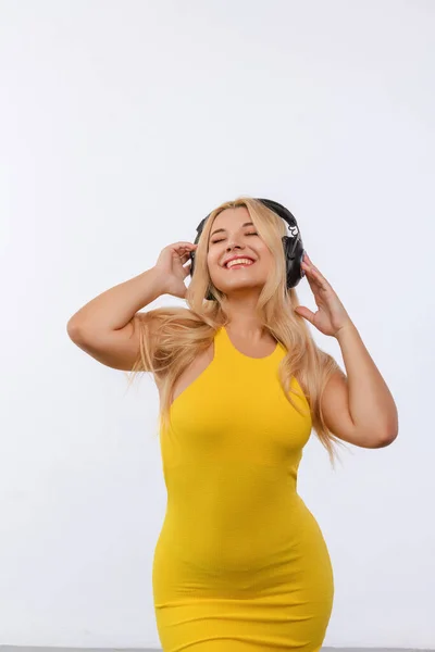 Beautiful Girl Black Headphones Yellow Dress Listens Music White Background — Stok fotoğraf