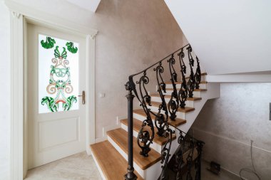 wooden stairs with metal wrought iron railings in a new house