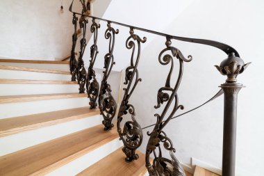 wooden stairs with metal wrought iron railings in a new house