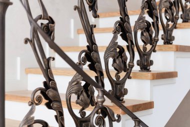 wooden stairs with metal wrought iron railings in a new house