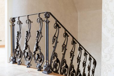wooden stairs with metal wrought iron railings in a new house