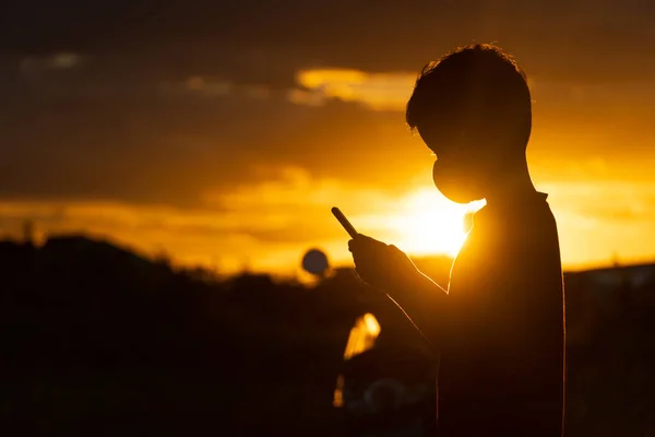 Silhouette Ασιατικό Αγόρι Χρησιμοποιώντας Smartphone Στο Ηλιοβασίλεμα — Φωτογραφία Αρχείου