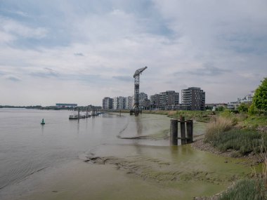 The last crane of Boelwerf on the side of the river Scheldt with luxury apartments in the background