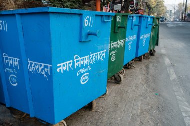 A close up shot of Dumpster i along side road in India. Written in hindi meaning municipal corporation , dehradun India