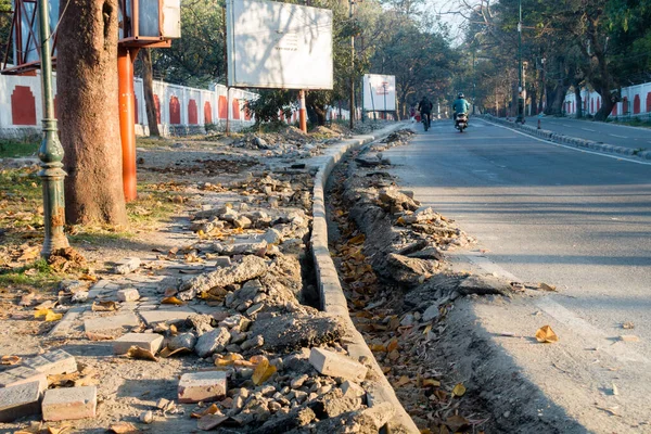A close up shot of dug up drainage along side road. An under construction drainage alongside road in India.