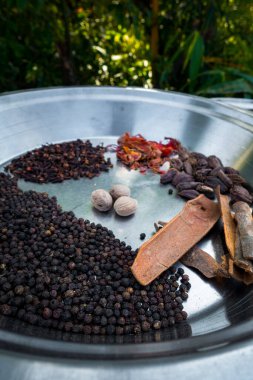 Büyük metal bir kasede kurutulmuş Hint baharatlarının yakın plan çekimi..