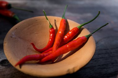 Ahşap bir yüzeye yerleştirilmiş kırmızı, uzun kırmızı biberli yakın çekim..