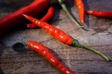 Ahşap bir yüzeye yerleştirilmiş kırmızı, uzun kırmızı biberli yakın çekim..