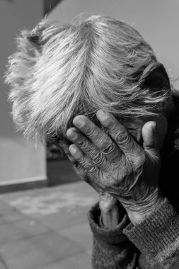 28th september 2020. Uttarakhand, India. A black and white shot of an old Indian lady having her wrinkled hands over her face in despair. clipart