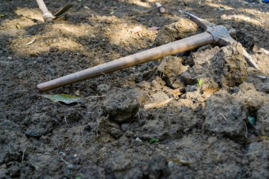 Toprakta duran el kazmasının izole edilmiş bir görüntüsü..
