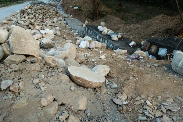 A pile of stone alongside road for constructing a stone retaining wall to prevent landslide and cutting. Uttarakhand India.