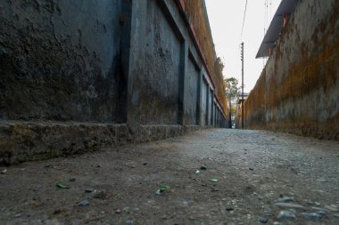 Her iki tarafında büyük duvarlar olan boş dar bir şeride yakın çekim. Uttarakhand Hindistan