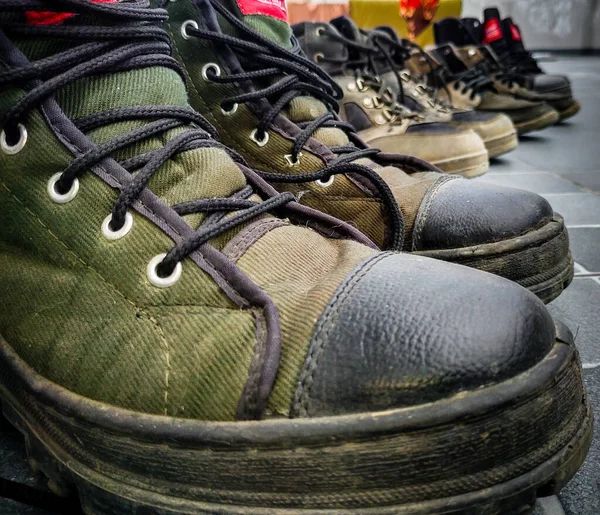Askeri eğitim botlarının yakın çekimi, koşudan sonra ayakkabılar dizilmiş. Uttarakhand Hindistan.