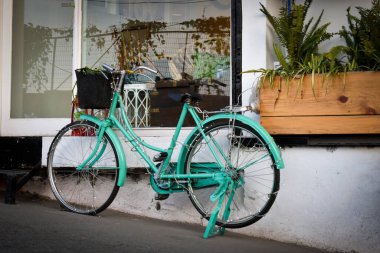 January 1st 2020 Mussoorie Uttarakhand India. A light green antique decorative ladies bicycle with basket outside a cafe for decorative purposes.