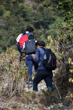 January 1st 2020 Uttarakhand INDIA. Hikers with backpacks and sticks ascending on a uphill trail.
