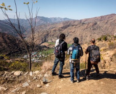 February 9th 2021 Uttarakhand INDIA. Hikers with backpack looking towards the valley of Mountains. Nag Tibba trek of Lower Himalayas.