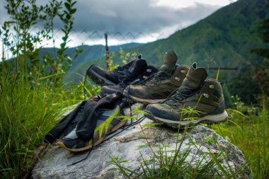 July 21st 2021. Uttarakhand India. Pair of trekking shoes and socks on a rock with landscapes and sky in the background.