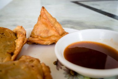 Demirhindi soslu ya da baharatlı Samosa. Samosa ya da singara, baharatlı patates, soğan ve bezelye gibi içerikleri içeren lezzetli bir dolgusu olan kızarmış ya da fırında pişirilmiş bir hamur işidir. Uttarakhand Hindistan.