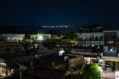 16 Mayıs 2022 Dehradun şehri Uttarakhand Hindistan. Arka planda Mussoorie Hills 'i aydınlatan Dehradun City yerleşim yeri çekimi.