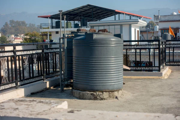 12 Şubat 2022, Dehradun Şehri Hindistan. Şehir merkezindeki bir binanın çatısında büyük plastik su tankları var..