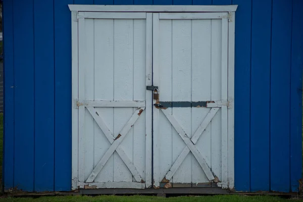 Mavi ahşap, kırsal, çift beyaz, kapalı kapılar. — Stok fotoğraf